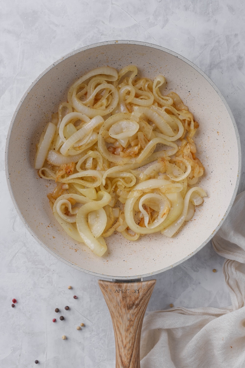 Sauteed onion slices in a white skillet.