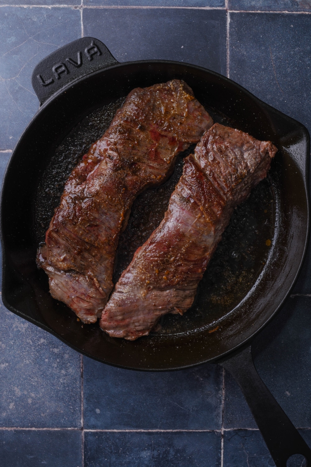 Seared skirt steak on a cast iron pan.