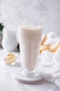 A glass filled with a banana protein shake.
