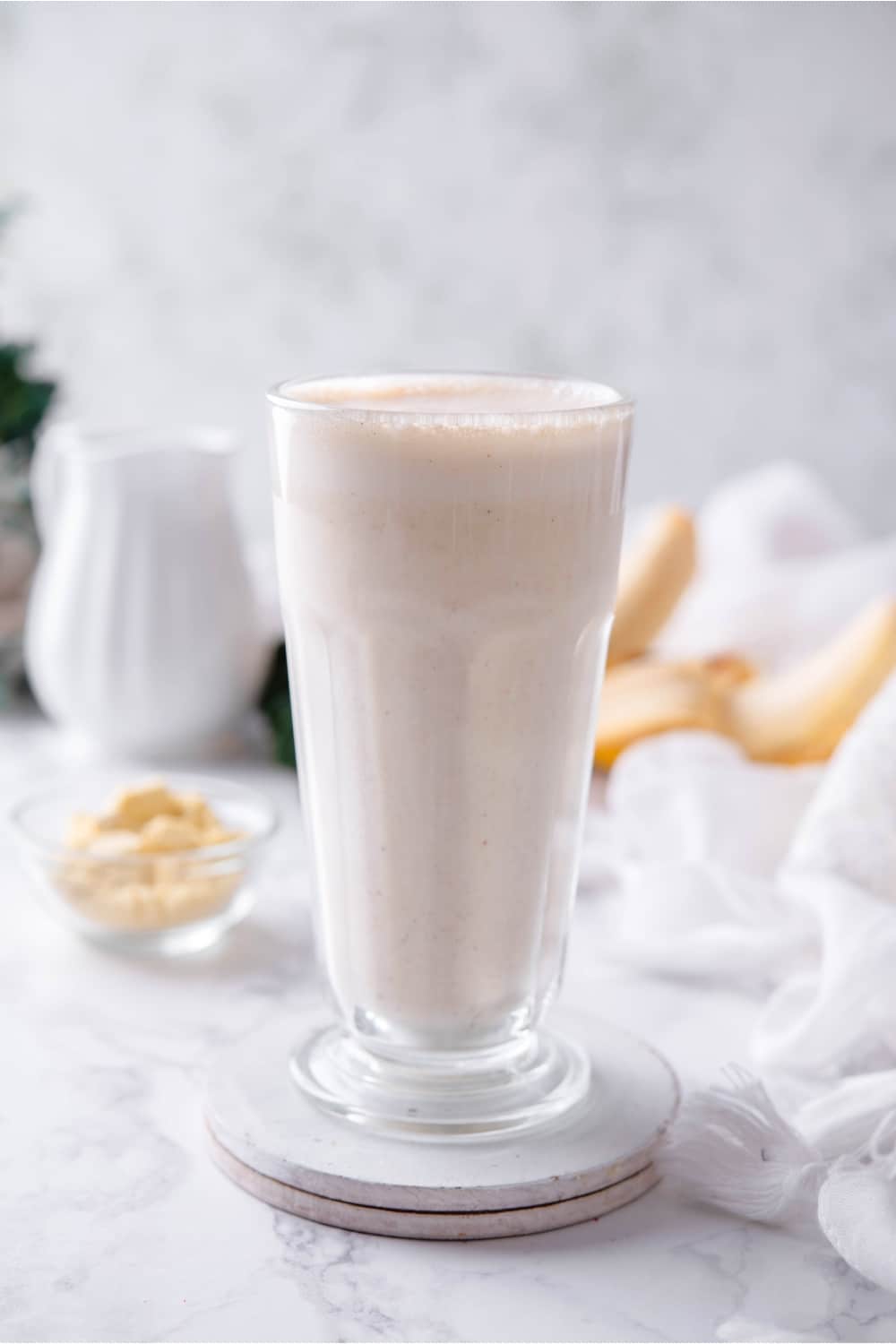 A glass filled with a banana protein shake.