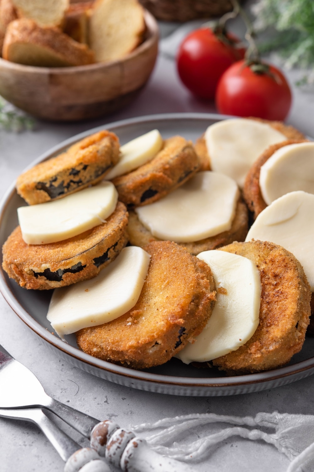 Fried eggplant slices layered with slices of mozzarella cheese on a plate.