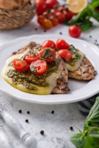 Grilled chicken margherita on a white plate.