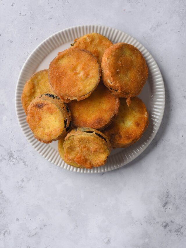 Fried eggplant slices on a white plate.