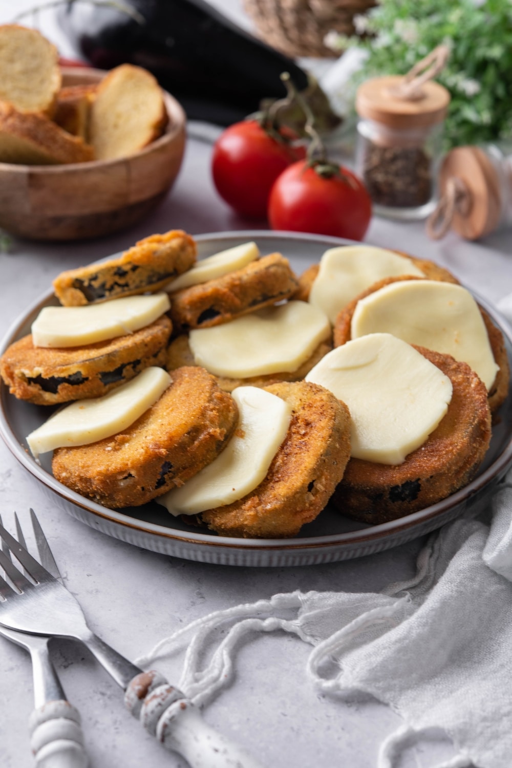 A plate of fried eggplant slices layered with mozzarella cheese slices.
