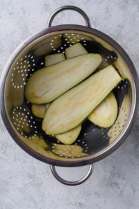 Eggplant slices in a colander.