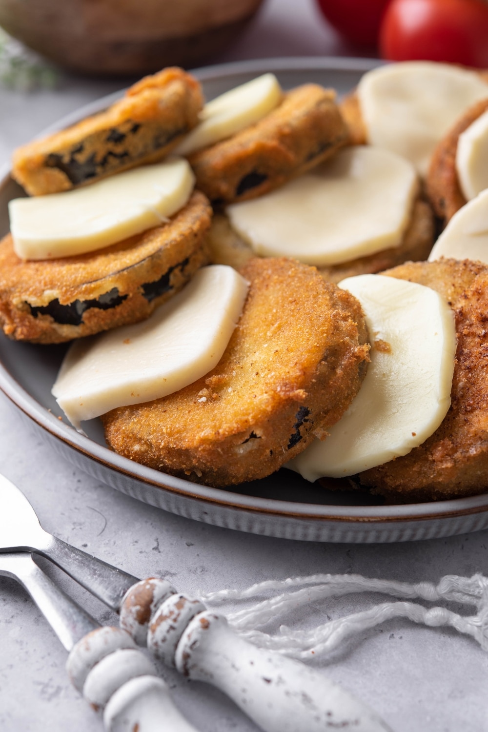 A closer look at fried eggplant slices with mozzarella cheese on a plate.