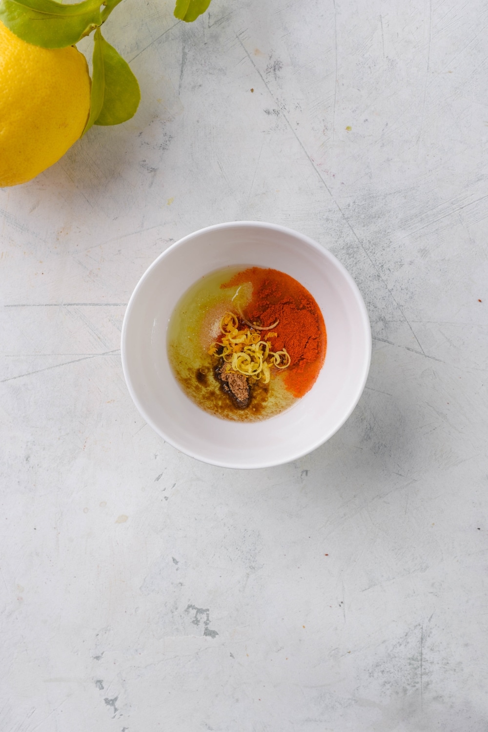 A small white bowl with olive oil and spices.