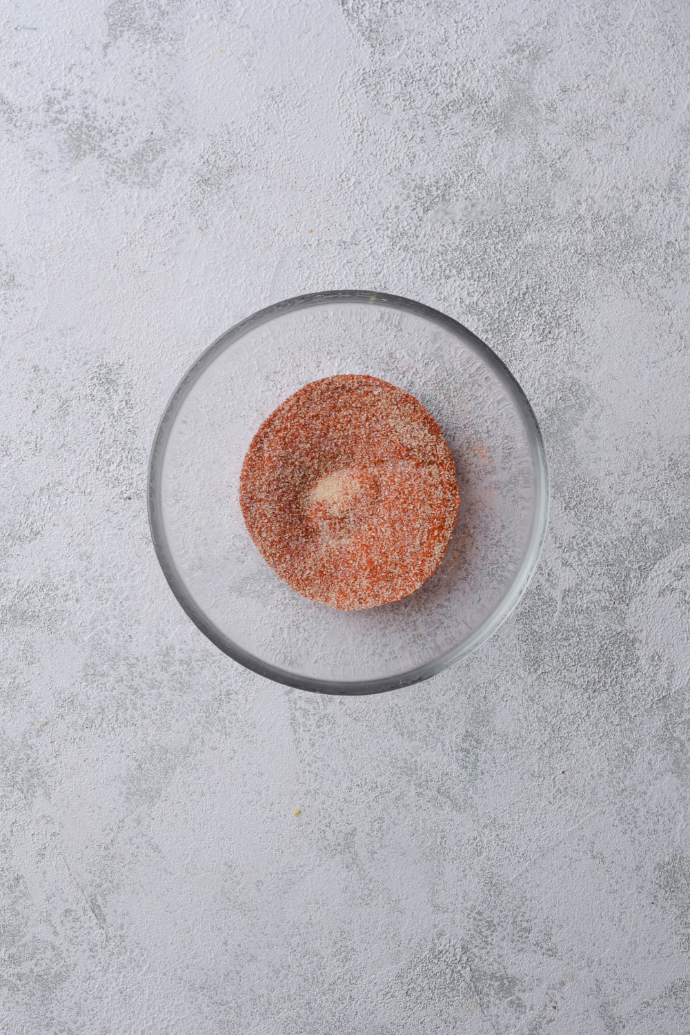 A small glass bowl of paprika, garlic powder, and baking powder.