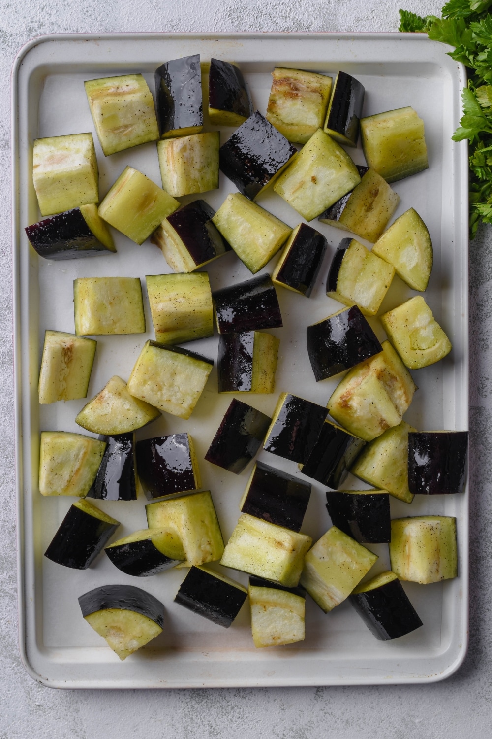 Chunks of eggplant spread out on a baking tray.