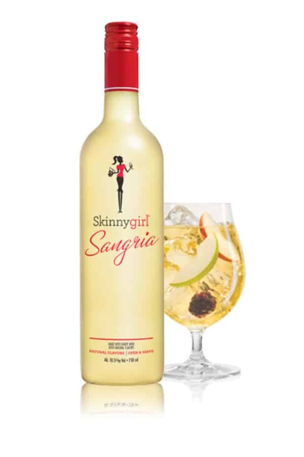 A bottle of skinnygirl margarita with a glass next to it.