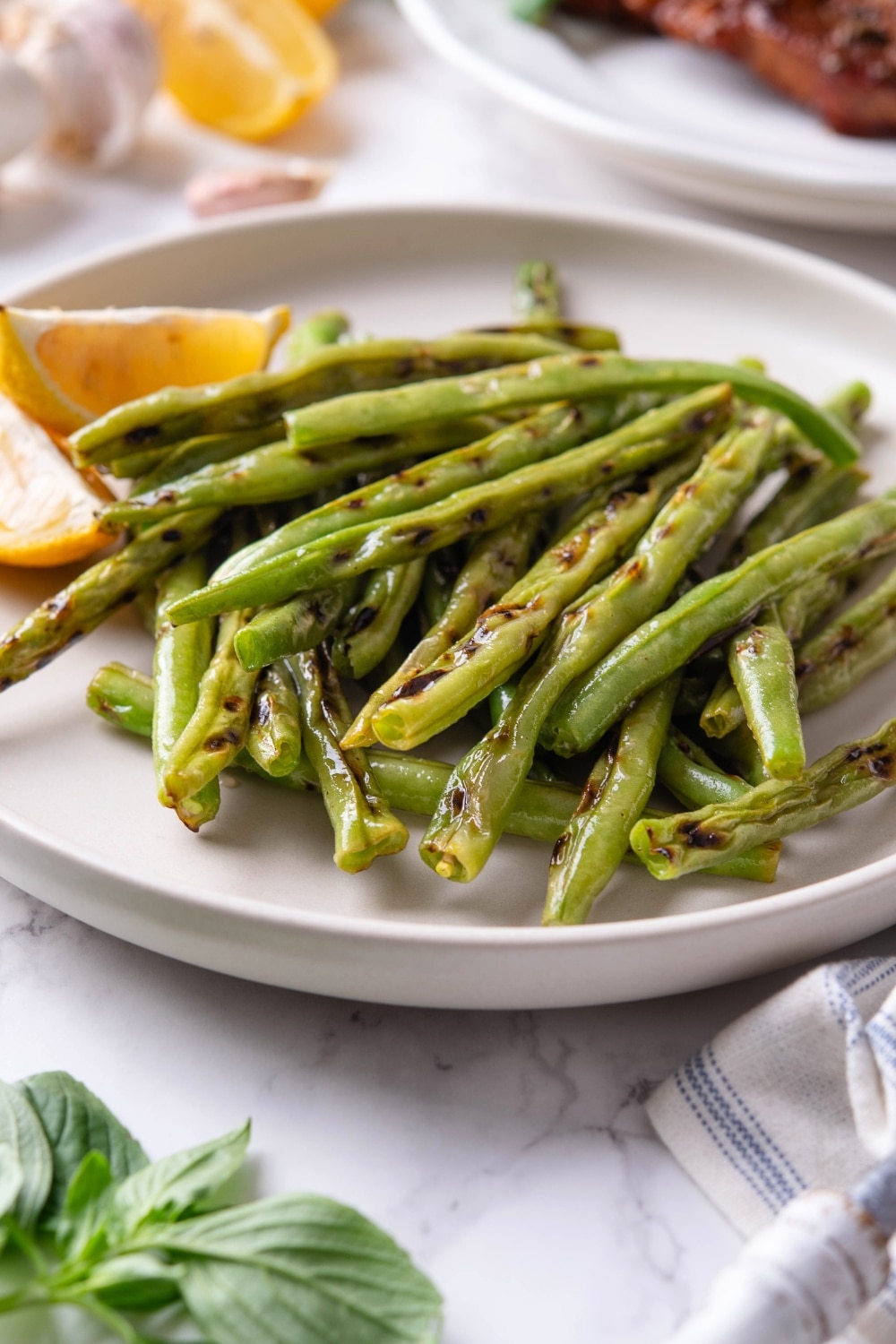 Grilled greens stacked on top of one another on a white plate.