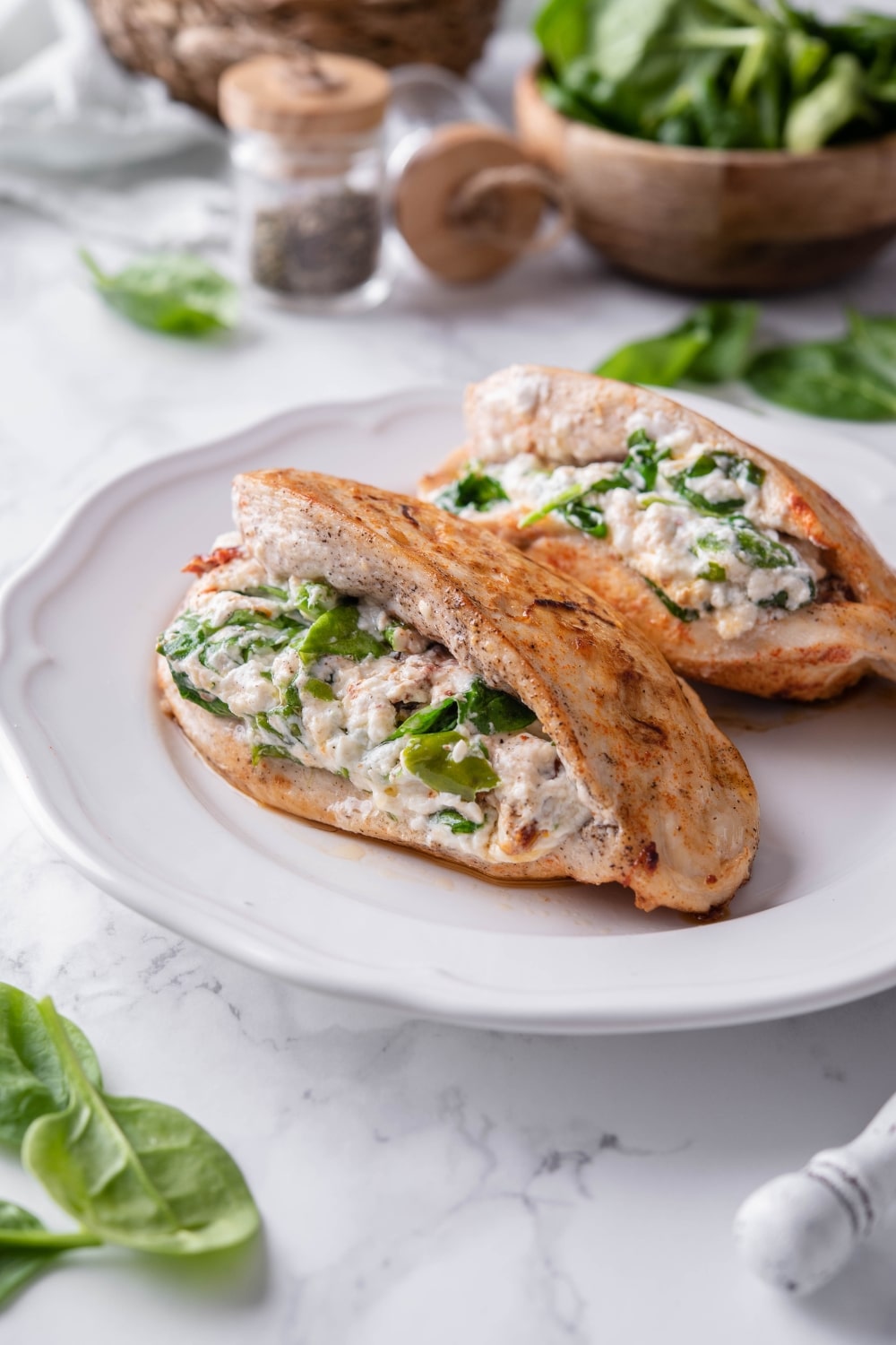 Two cheese, spinach, and sundried tomatoes stuffed chicken breasts on a plate.