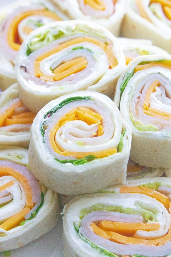 A bunch of sliced turkey roll ups.