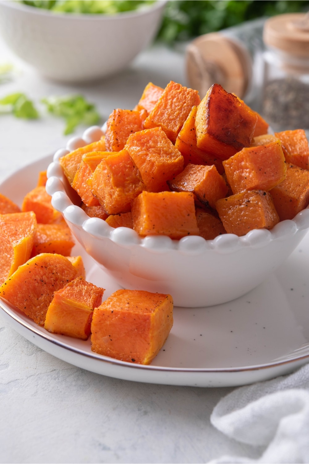 A bowl of roasted butternut squash on a plate.