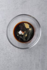 A glass bowl of unmixed Szechuan sauce ingredients.