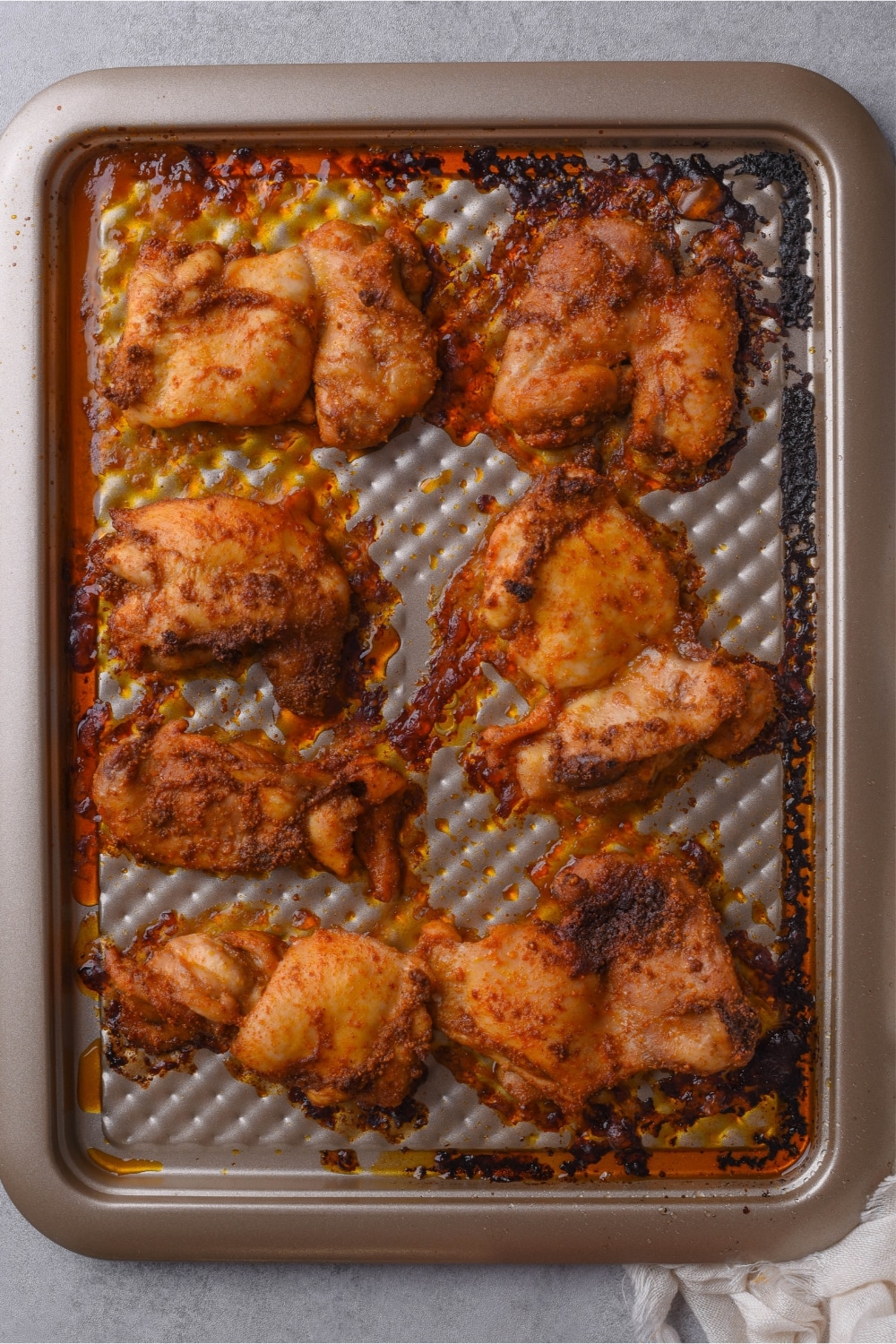 Baked boneless skinless chicken thighs on a baking sheet.