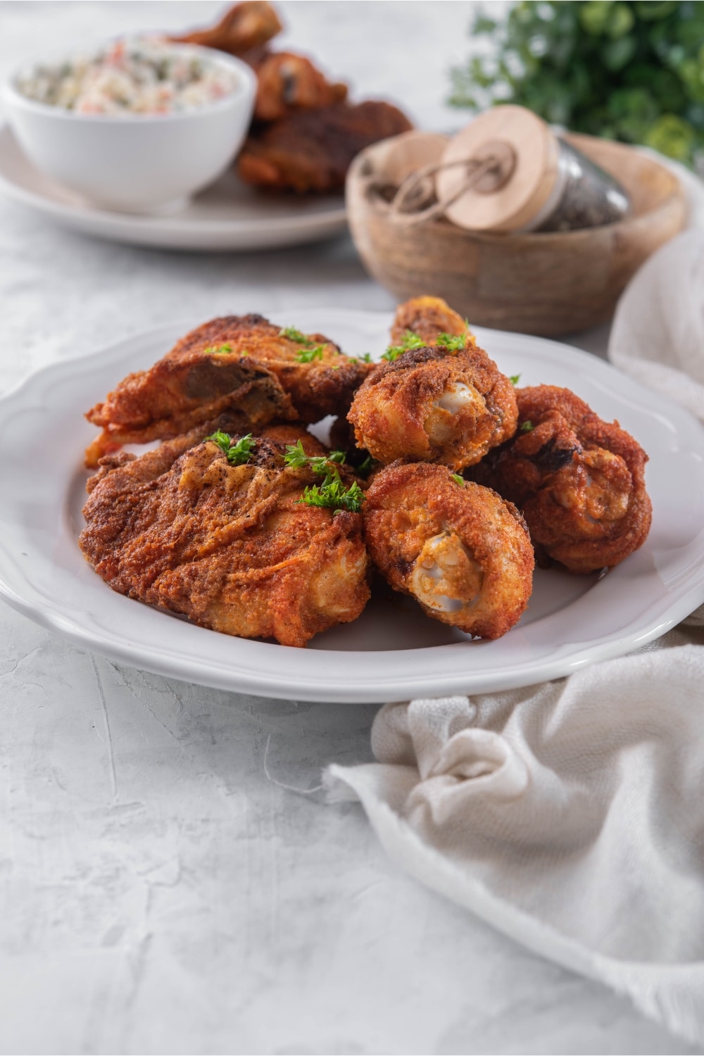 Baked chicken legs and thighs on a plate garnished with parsley.