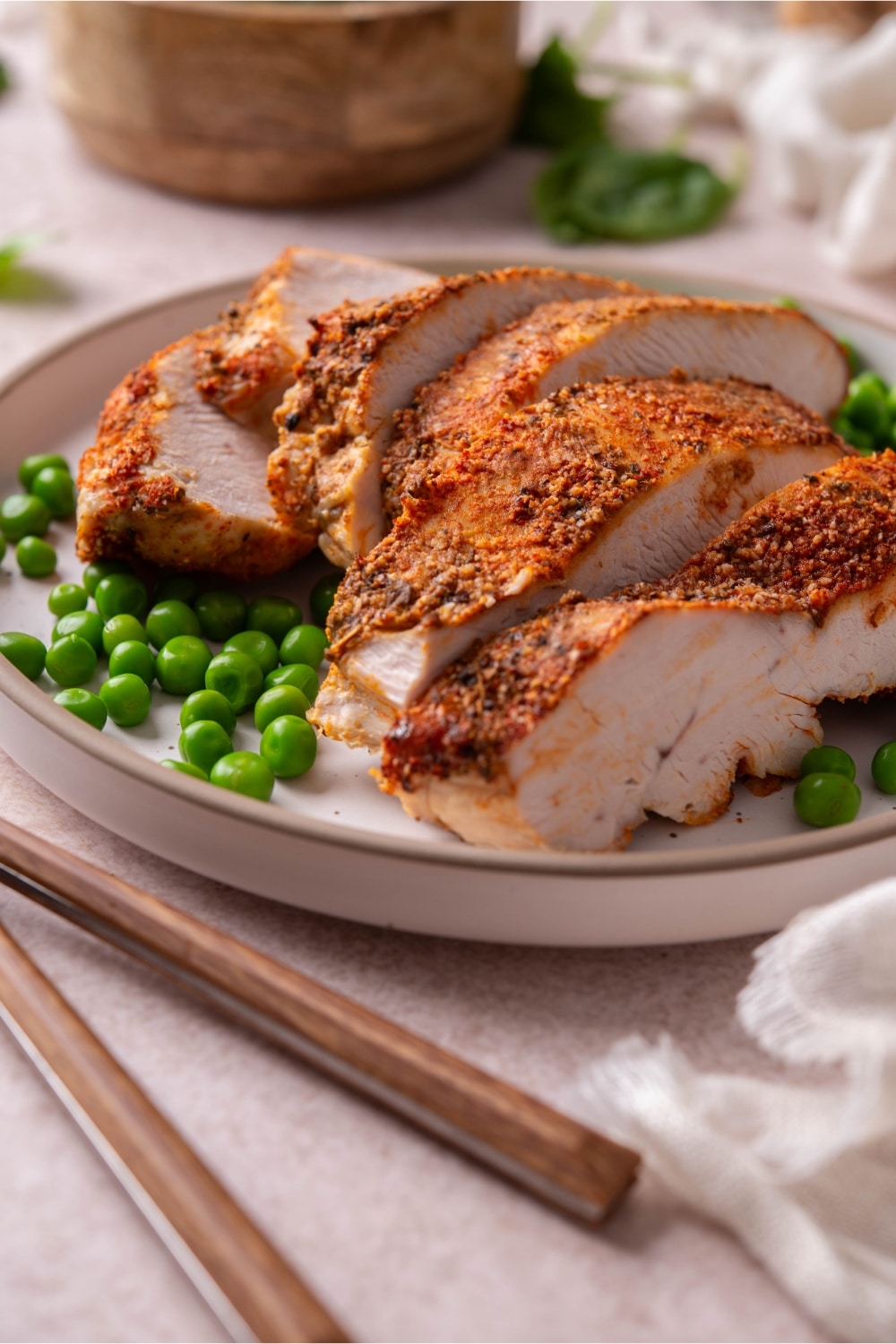 A closer look at baked boneless skinless turkey breast and green peas on a plate.