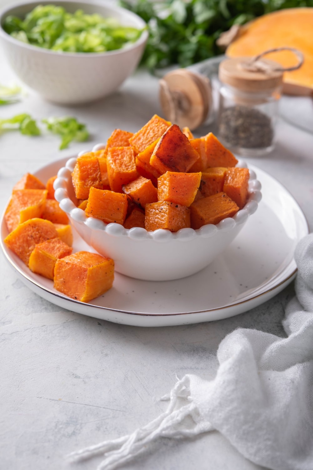 A bowl of cubed roasted butternut squash on a plate.
