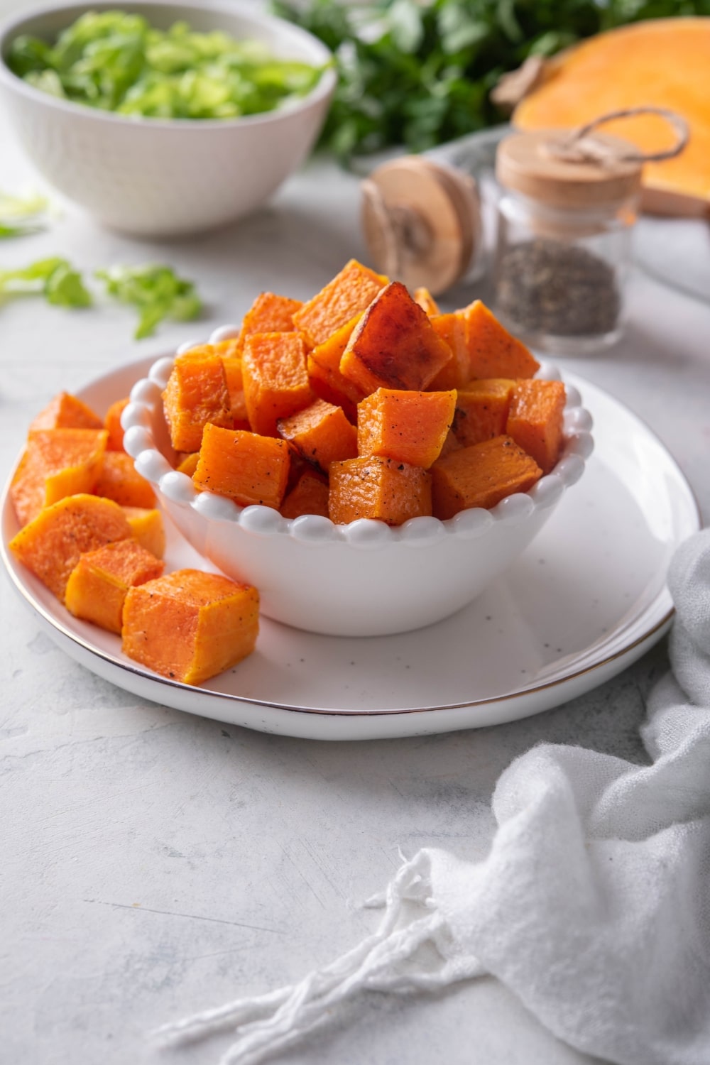 A bowl of cubed roasted butternut squash on a plate.