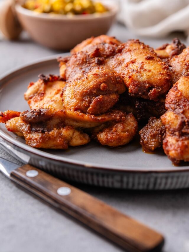 A closer look at baked boneless skinless chicken thighs on a plate.