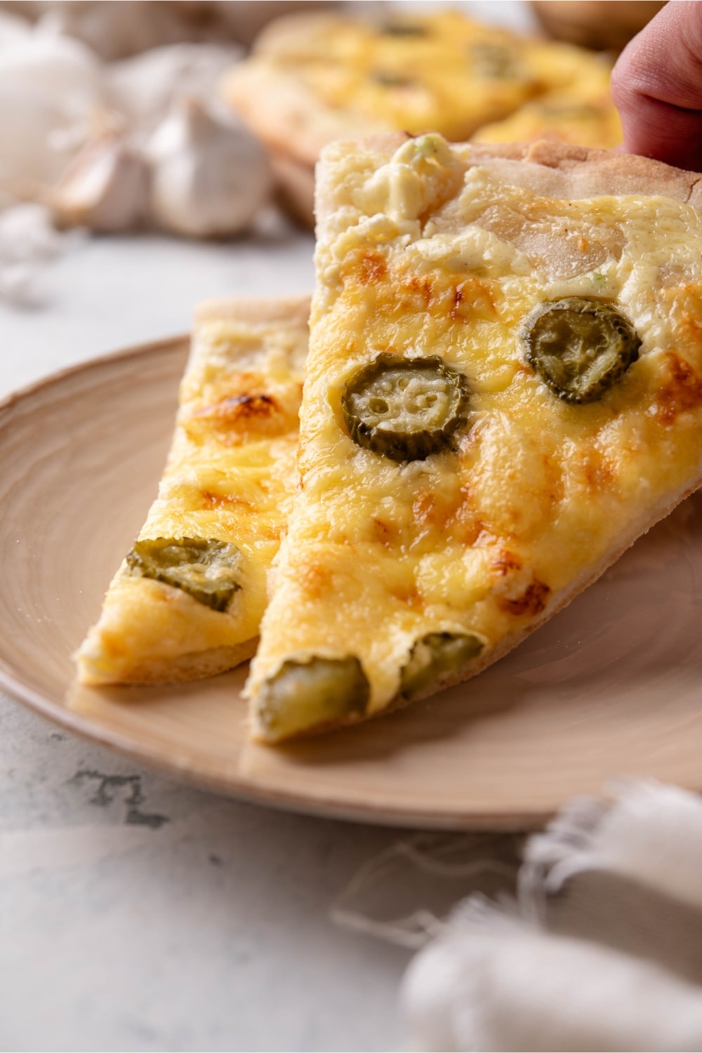 A closer at a slice of dill pickle pizza on a plate.