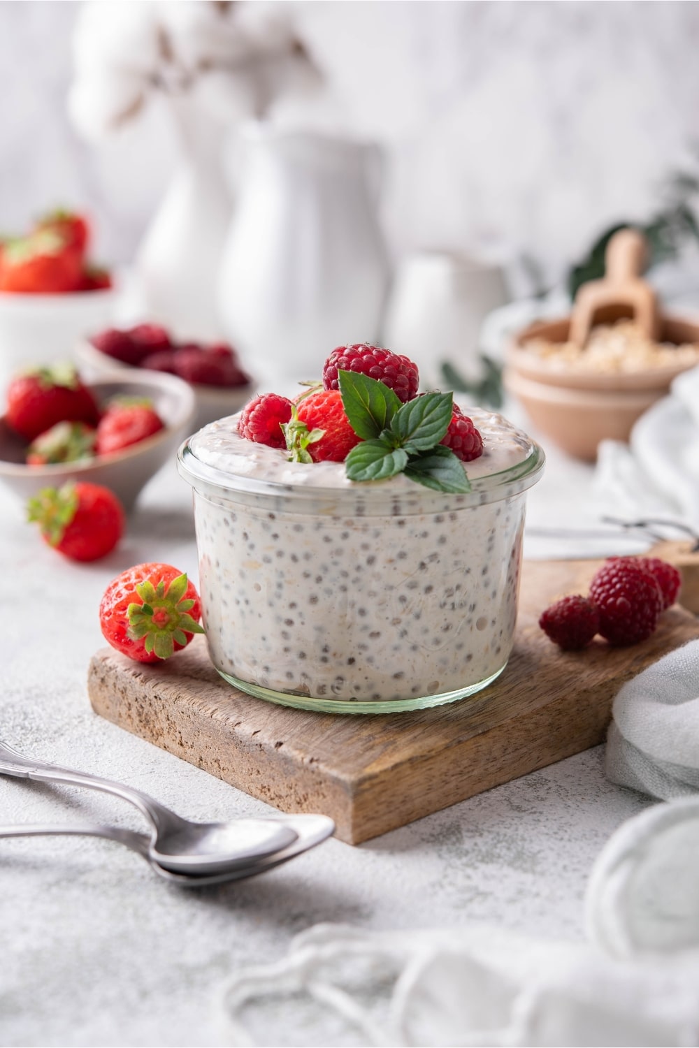 A glass of overnight oats garnished with strawberries and raspberries.