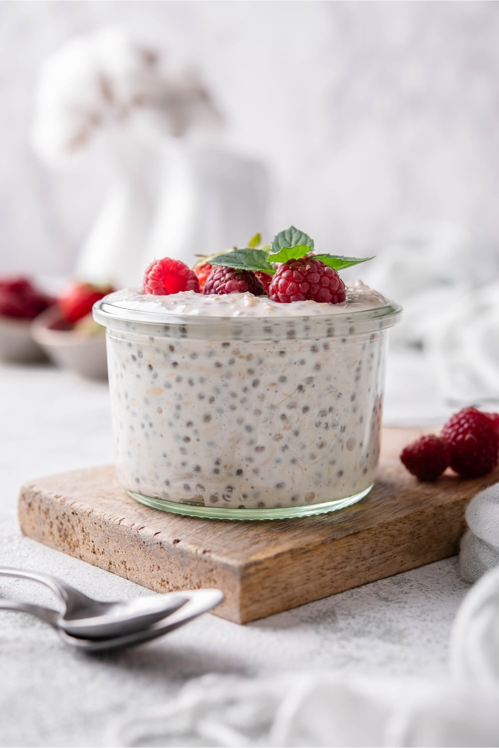 Overnight oats served in a glass topped with strawberries and raspberries.