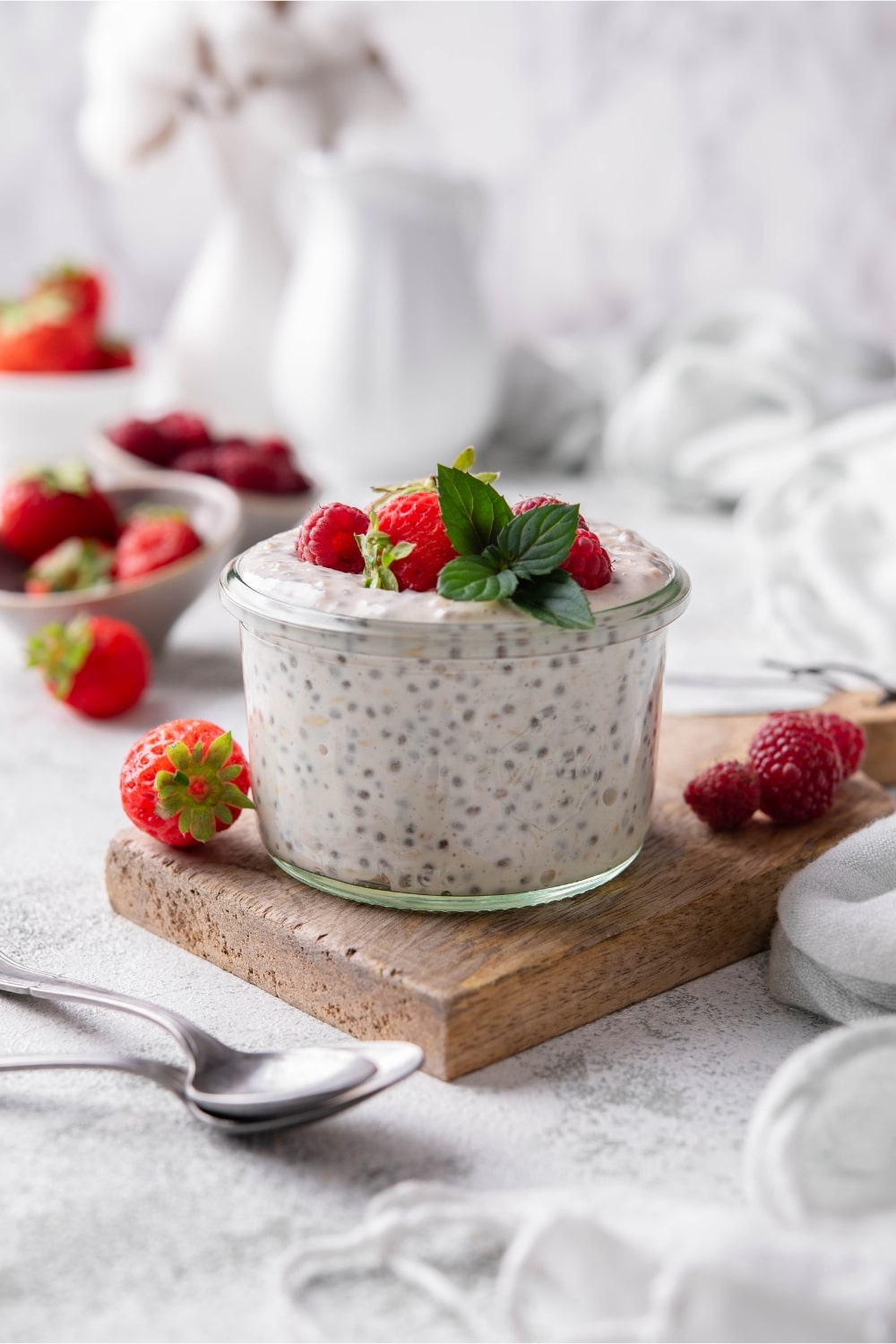 Overnight oats garnished with strawberries and raspberries in a glass.