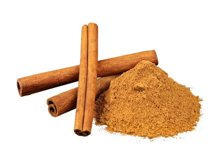 Three cinnamon sticks and a mound of ground cinnamon.