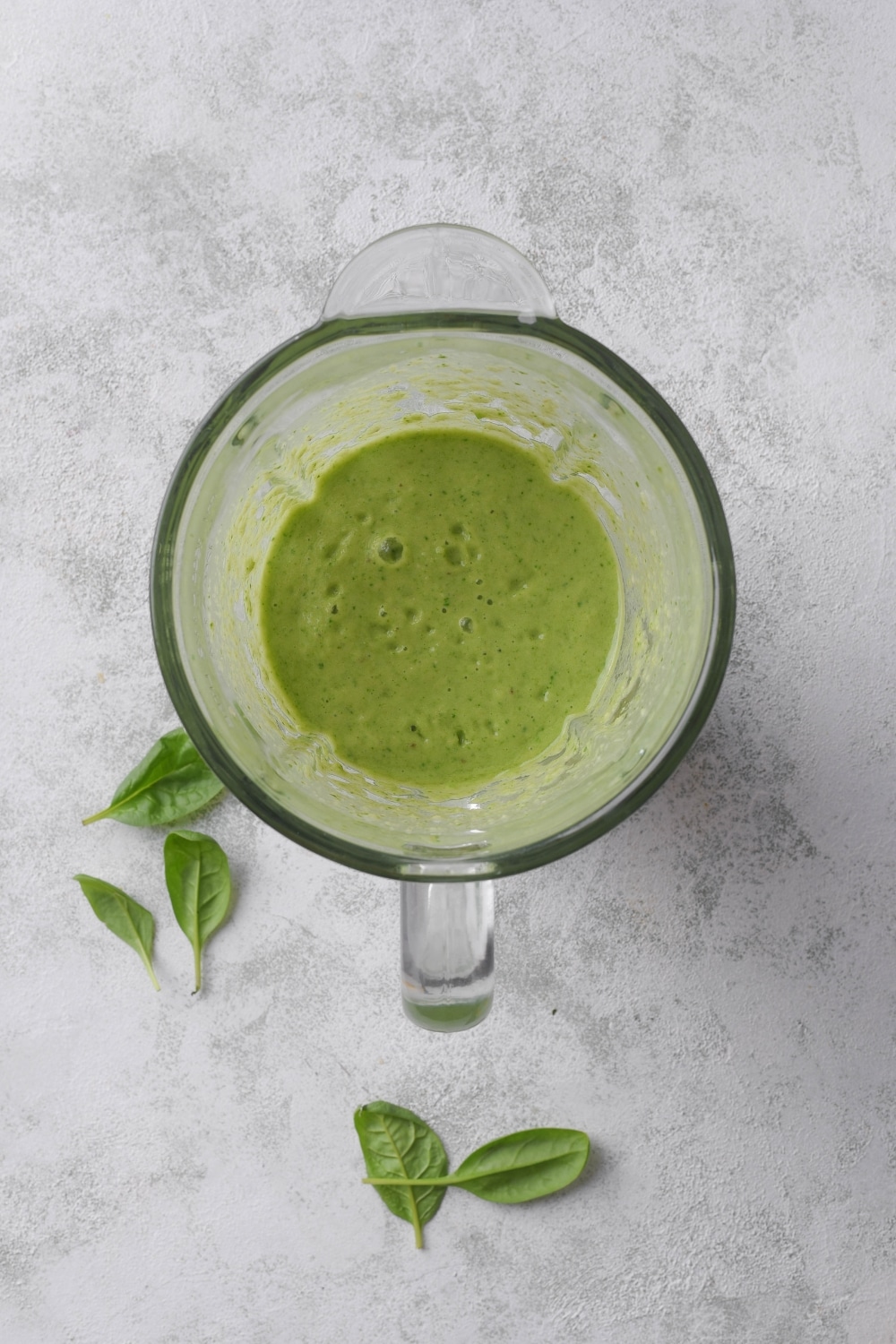 A blender filled with a green smoothie.