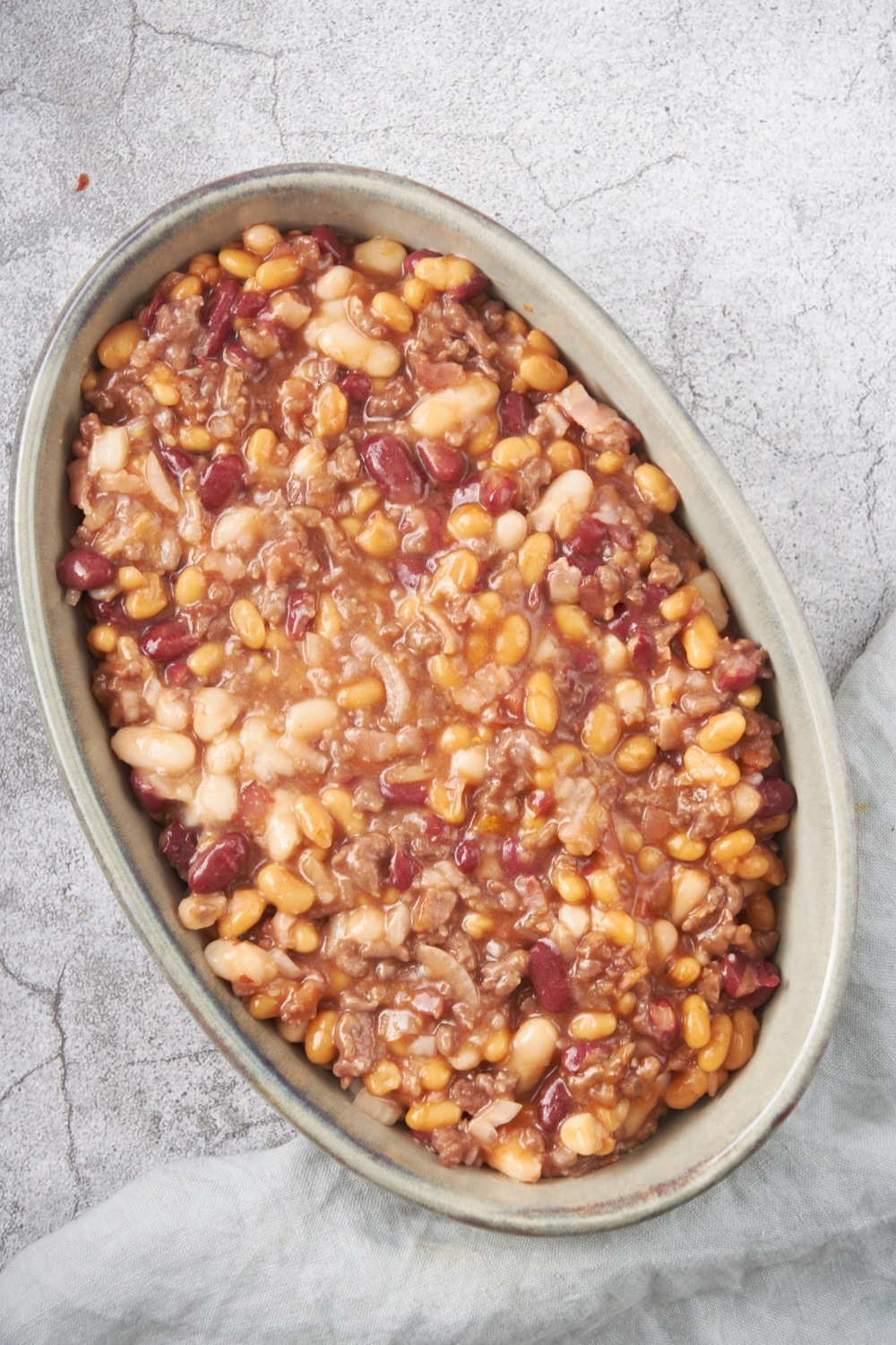 A baking dish filled with a mixture of beans and ground beef.