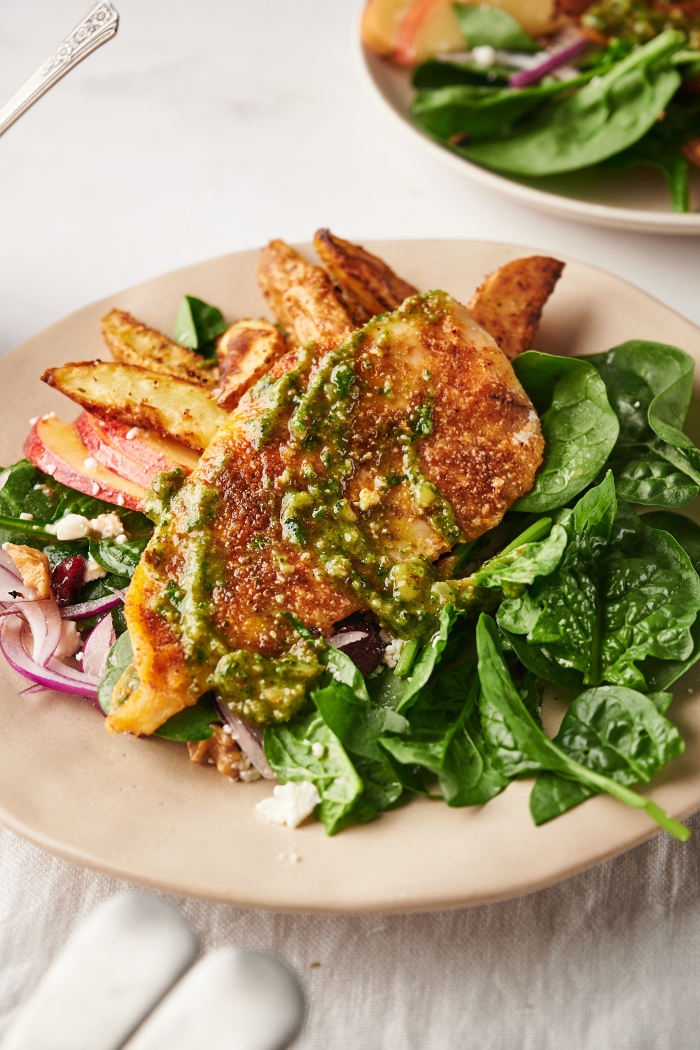 Baked catfish on a plate with spinach.