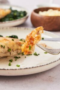 A fork with a piece of chicken on it.