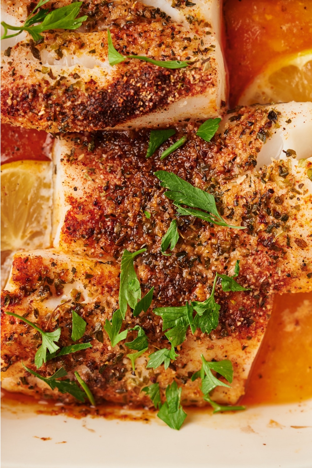 Parts of three mahi mahi fillets with seasonings on top.