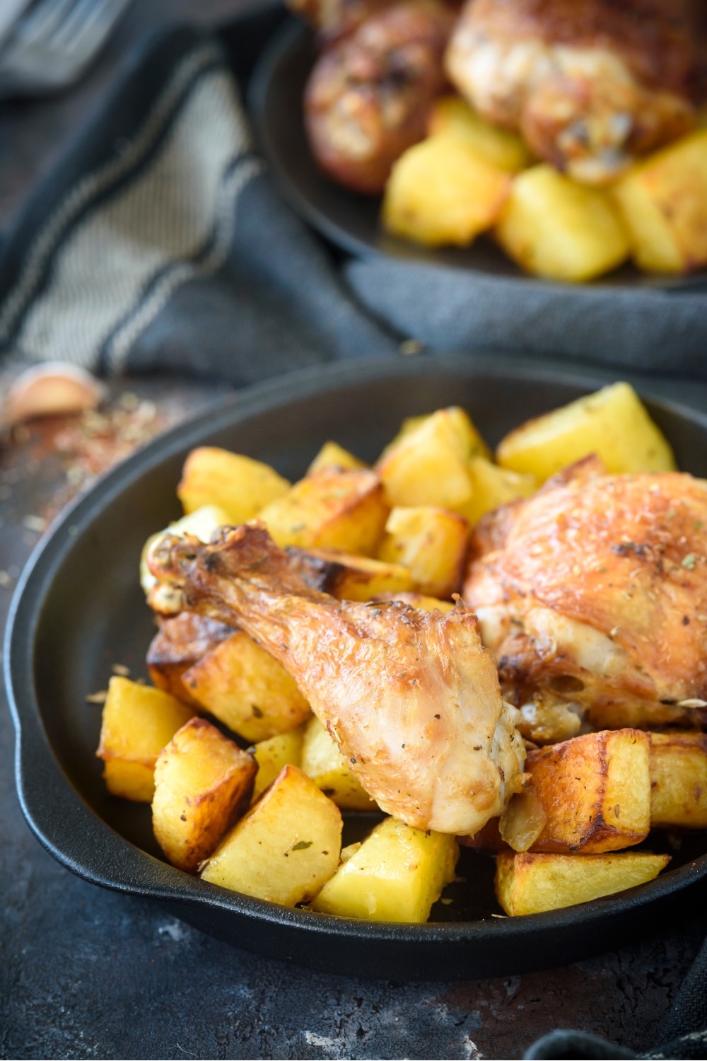A chicken drumstick and potatoes on a plate.