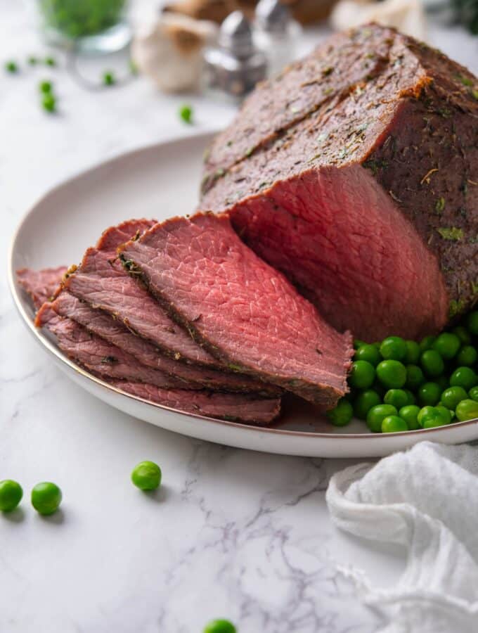 A closer look at sliced medium rare sirloin tip roast on a plate.