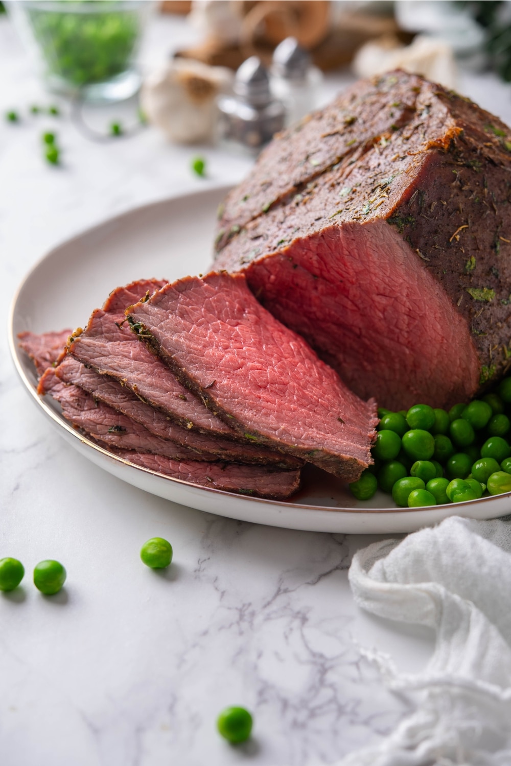 A closer look at sliced medium rare sirloin tip roast on a plate.