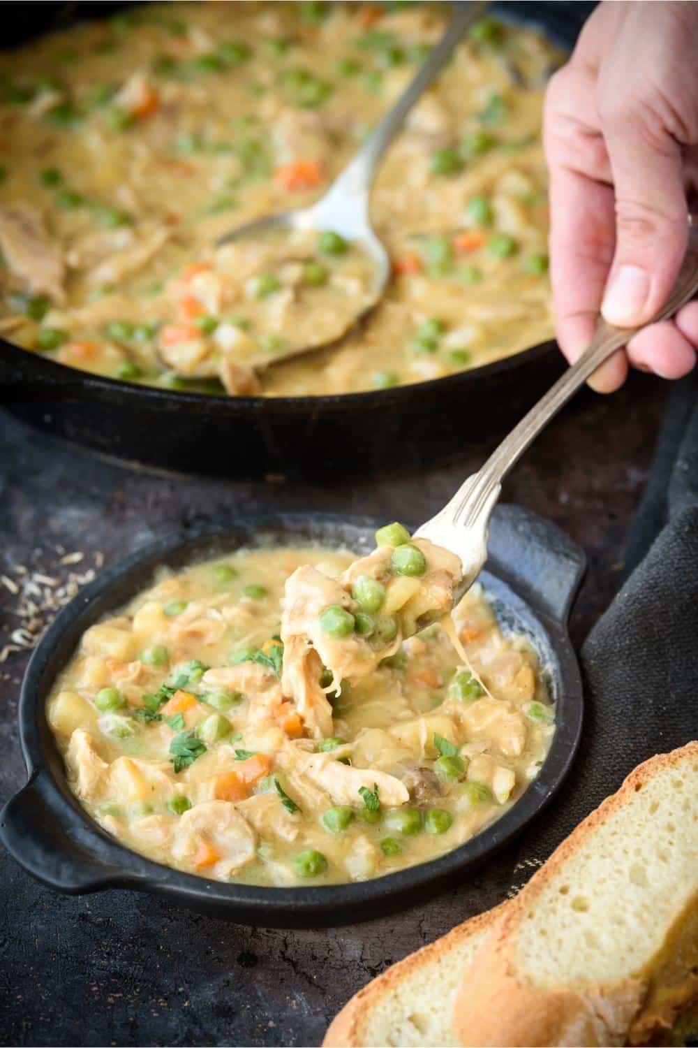 A fork lifting a portion of crustless chicken pot pie out of a small serving pot.