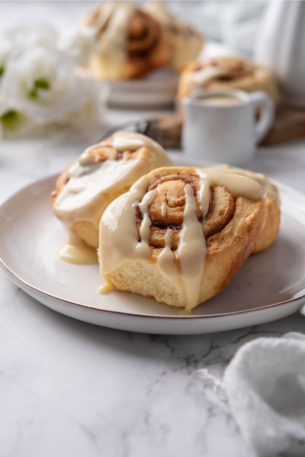 Glazed protein cinnamon rolls on a plate.