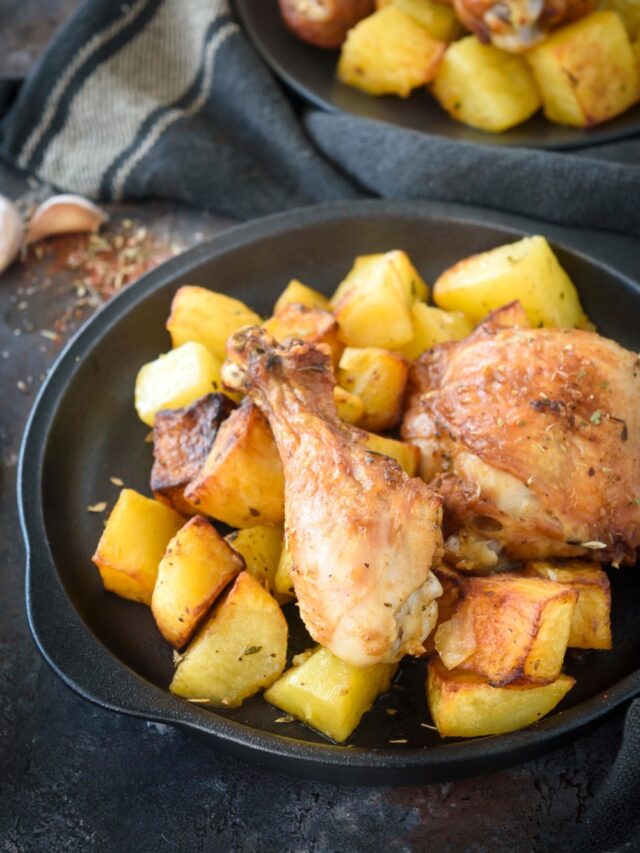 Two pieces of chicken on top of potatoes on a plate.