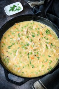A large cast iron pot of crustless chicken pot pie.