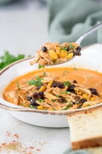 A spoonful of chicken enchilada soup over a full bowl.