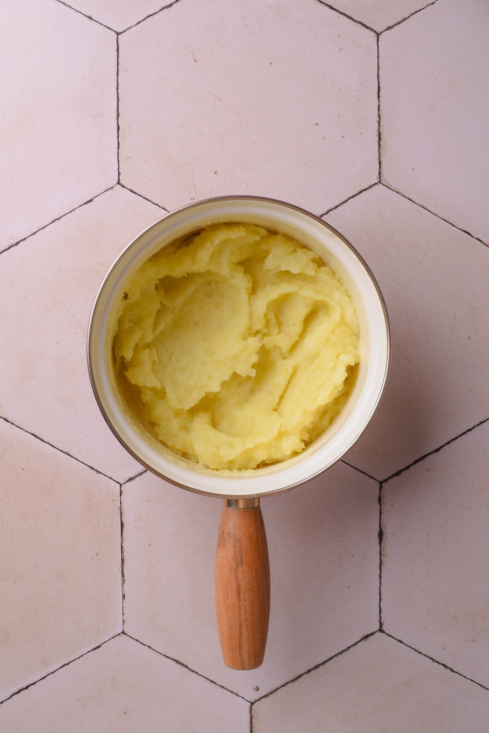 Mashed potatoes in a pot on a white counter.