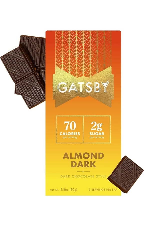 A Gatsby almond dark chocolate bar packaged with a few chocolate squares next to it.