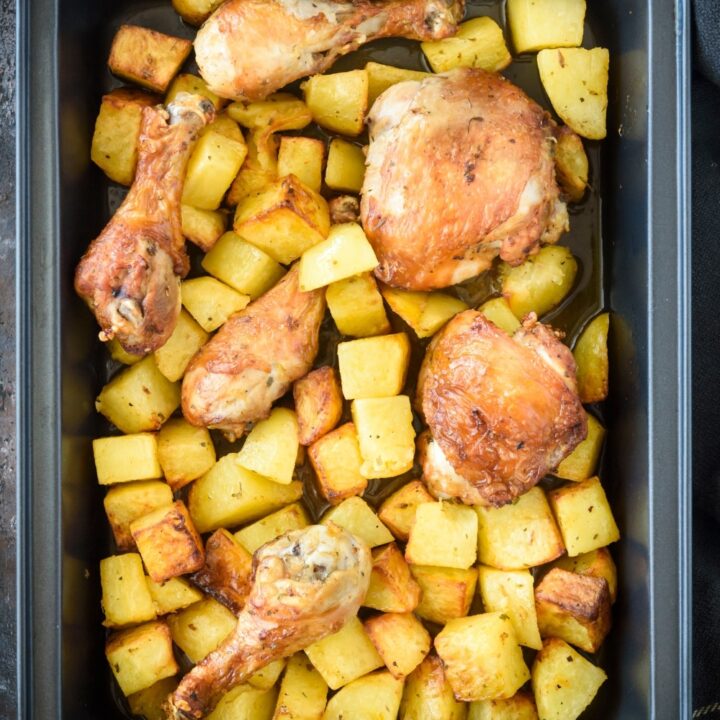 Chicken and potatoes in a black baking dish.