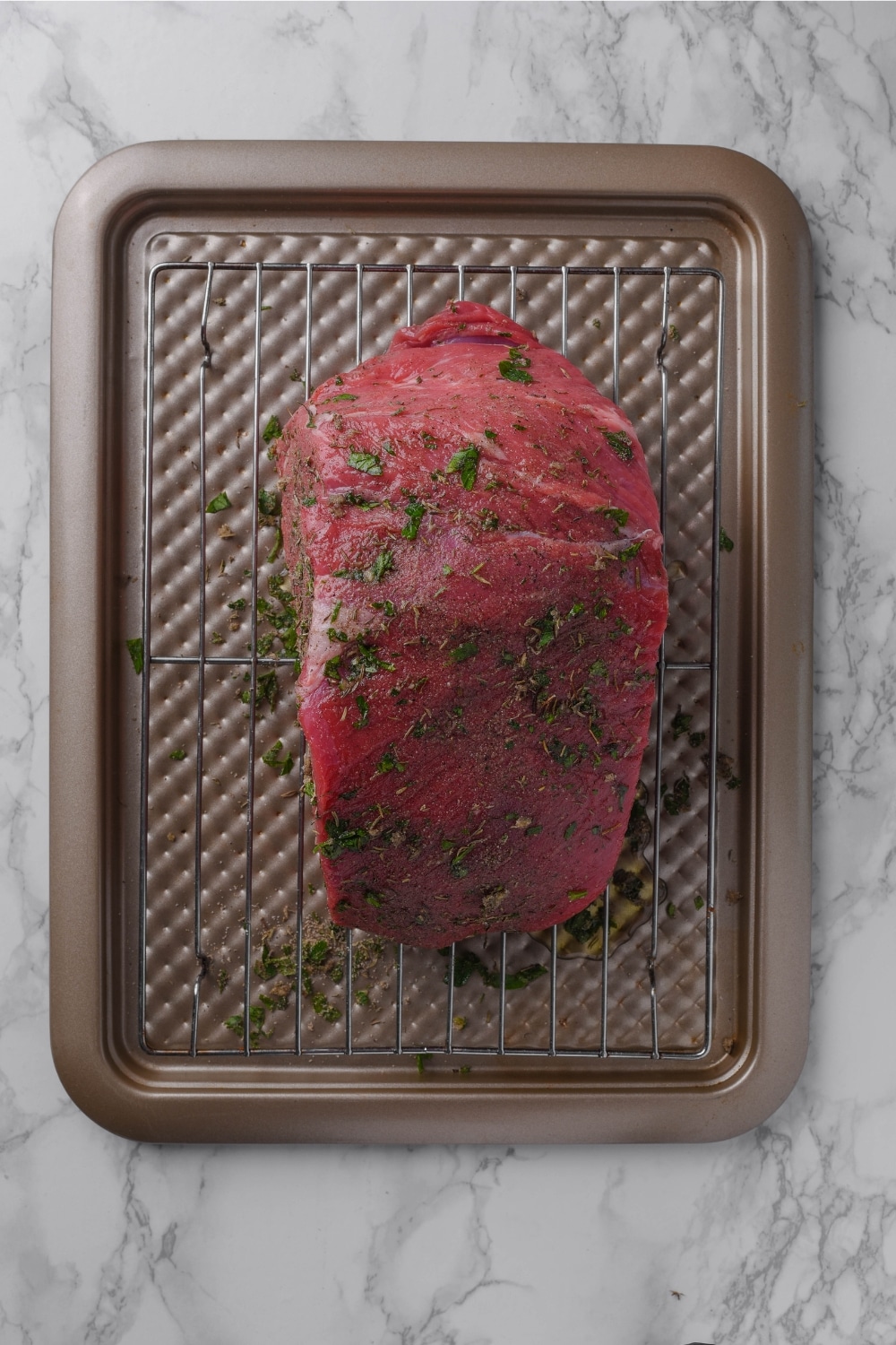 Seasoned sirloin tip on a roasting pan.