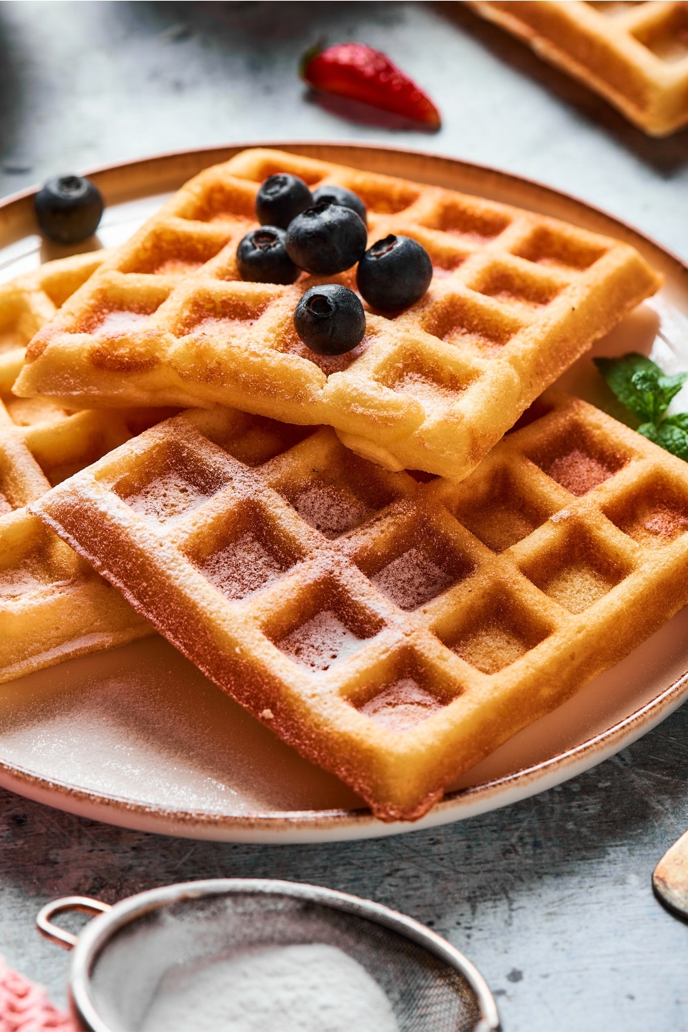 A waffle stacked on top of some more waffles on a plate.