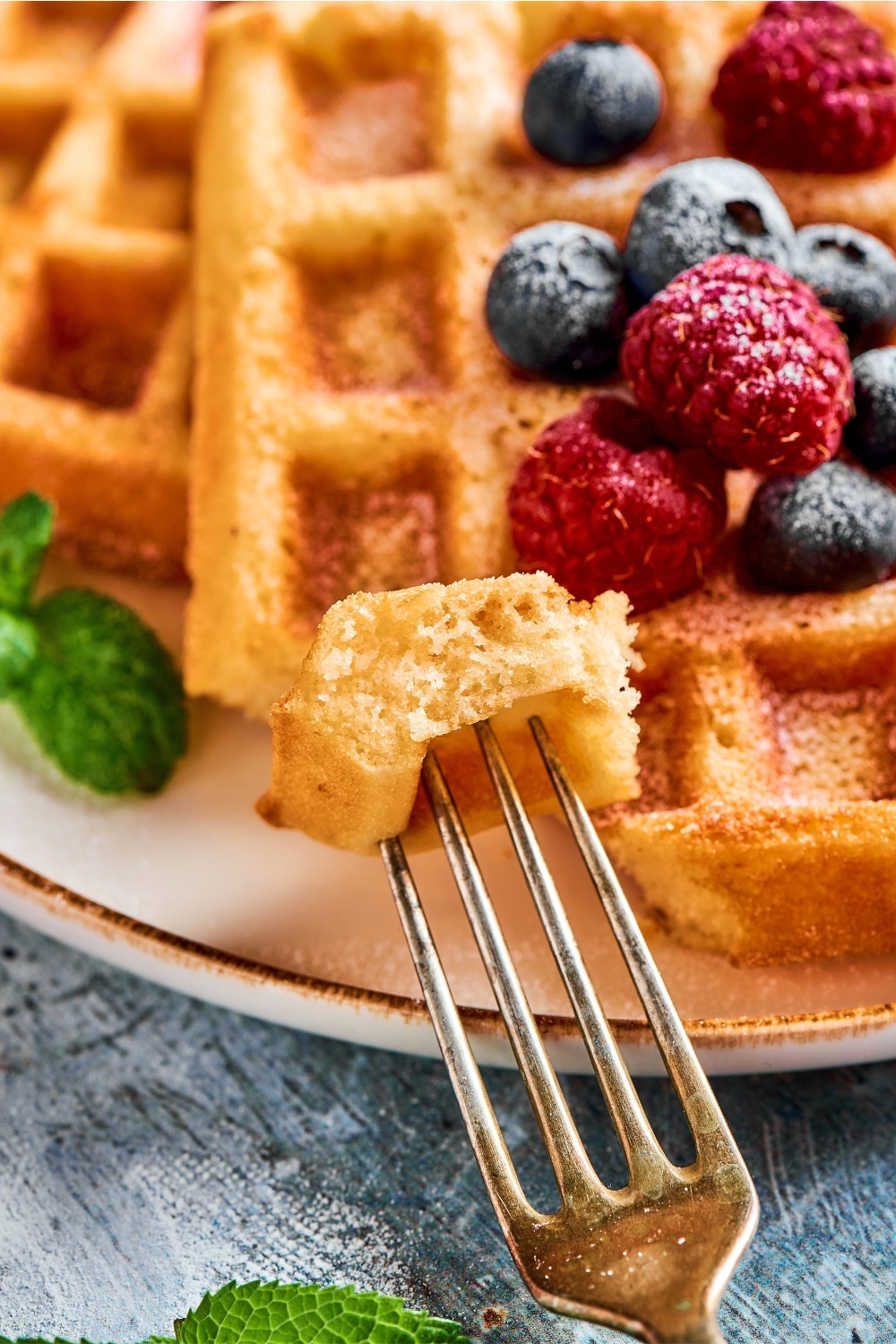 A fork with a piece of waffle on it.