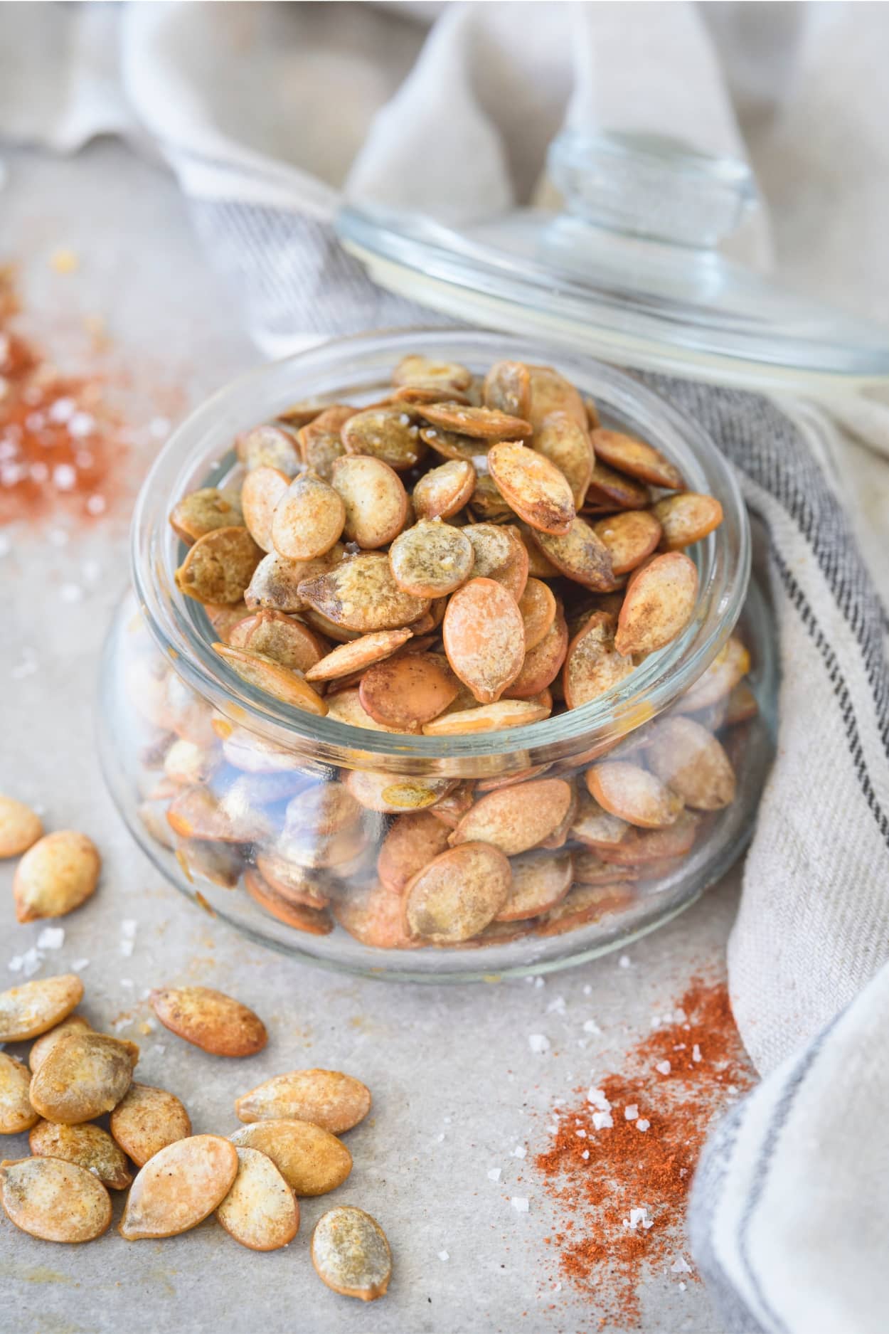 A glass jar that is filled with pumpkin seeds.